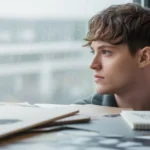 Personne créative regardant par la fenêtre par ennui, illustrant le lien entre l'ennui et la créativité selon la science